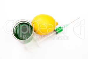 Lemon next to beaker and a syringe
