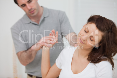 Woman sitting while being stretched by a physiotherapist