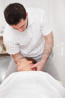 Therapist manipulating the neck of his patient while standing