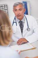 Doctor sitting at his desk looking at a patient