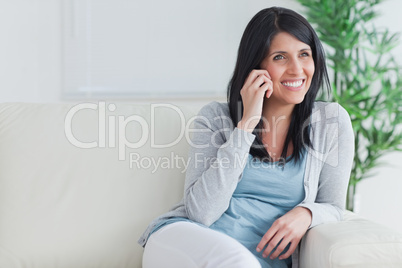 Woman talking on the phone while relaxing on a couch