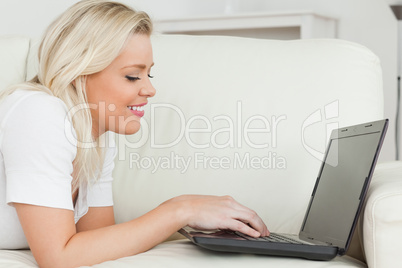 Woman lying while using a laptop