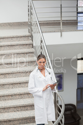 Front view of a doctor touching a tablet computer