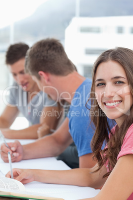 Close up of a woman smiling into the camera as the other people