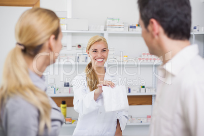 Pharmacist giving a drug bag to patients