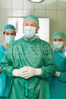 Surgeon joining his hand with interns behind him