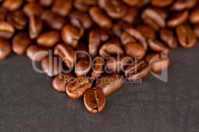 Blurred coffee seeds laid out together on a black table