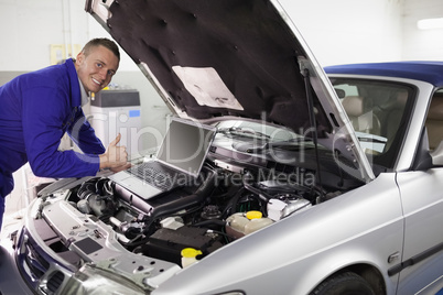 Mechanic leaning on a car engine