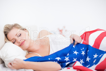 Blonde woman sleeping with a US flag