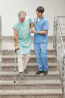 Male nurse assisting a patient on stairs