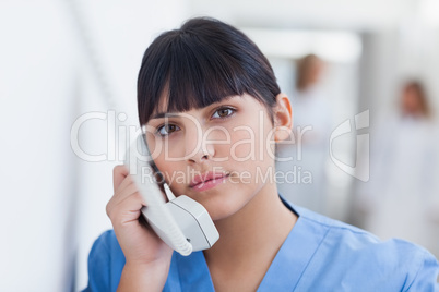 Nurse holding a phone in corridor