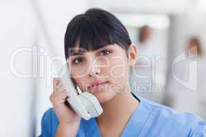 Nurse holding a phone in corridor