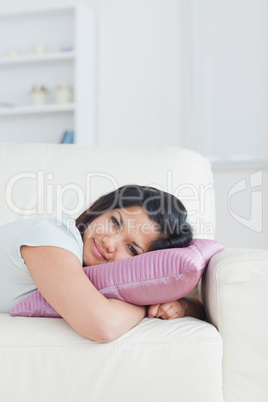 Woman relaxing on a sofa with her head on a pillow
