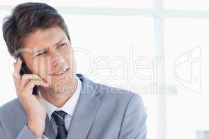 Stern businessman talking on the phone while looking towards the