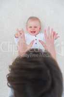 High view of a baby lying on back while playing