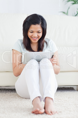Laughing woman sitting on the floor while playing with a tactile