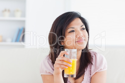 Woman smiling and holding a glass of orange juice