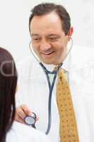 Doctor holding a stethoscope with a patient