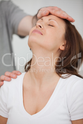 Doctor posing his hand on the forehead of a patient