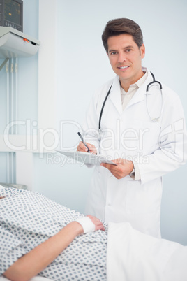 Doctor writing on his chart