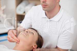 Physiotherapist pressing two fingers on the neck of his patient
