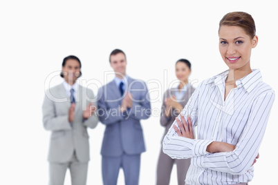 Close-up of a woman crossing her arms with business people appla