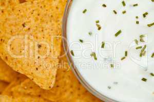 Close up of a bowl of white dip  beside nachos