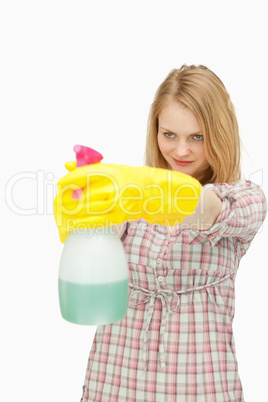 Young woman smiling while holding a spray bottle