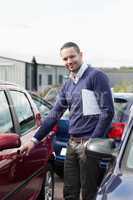 Man holding a car handle while holding a file