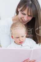 Mother reading a book to a baby