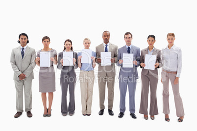 Business people holding six supports for letters