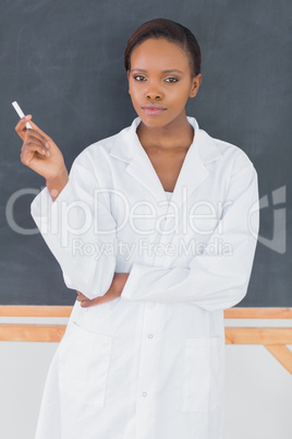 Teacher holding a chalk while standing up