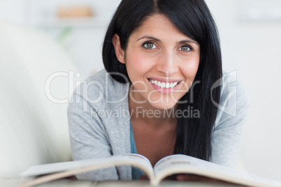 Woman smiling and lying on a sofa