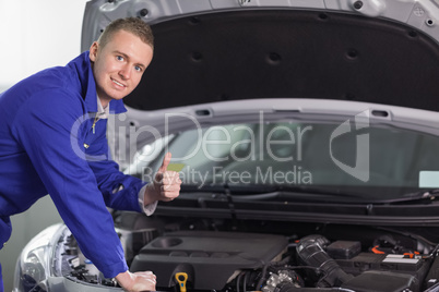 Mechanic looking at camera with his thumb up