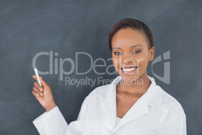 Black woman holding a chalk while smiling