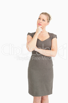 Woman standing with a finger on her chin