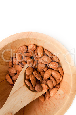 Wooden spoon with almonds in a bowl