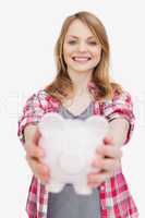 Focus of a woman holding a piggy bank