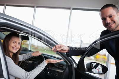 Woman sitting in her car while tending her hand