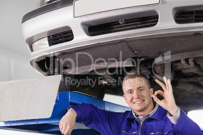 Smiling mechanic doing a gesture with his hand