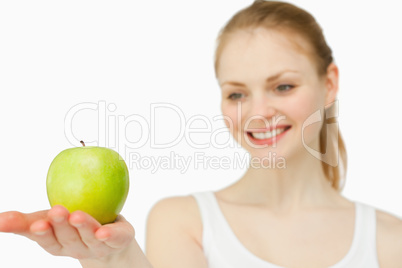 Woman smiling while presenting an apple