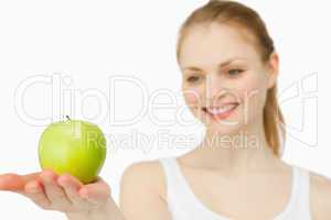 Woman smiling while presenting an apple