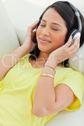 Close-up of a smiling Latino enjoying music on a smartphone