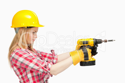 Serious woman using an electric screwdriver
