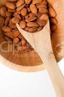 Wooden spoon with almonds in in a bowl