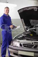 Smiling mechanic holding a clipboard and a pen
