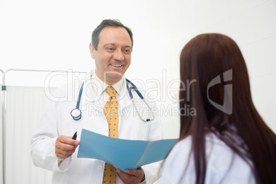 Doctor holding a document while talking to a patient