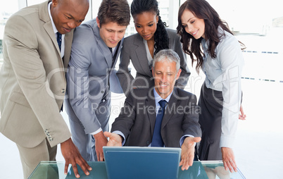 Mature manager sitting at the desk surrounded by his serious tea