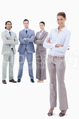 Secretary smiling with serious business people in background