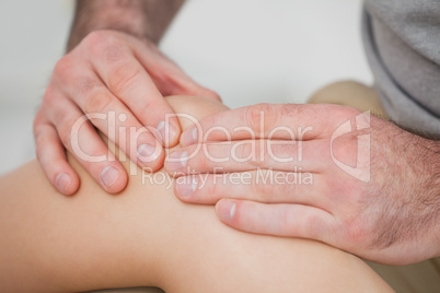 Close-up of hands making a massage on a knee